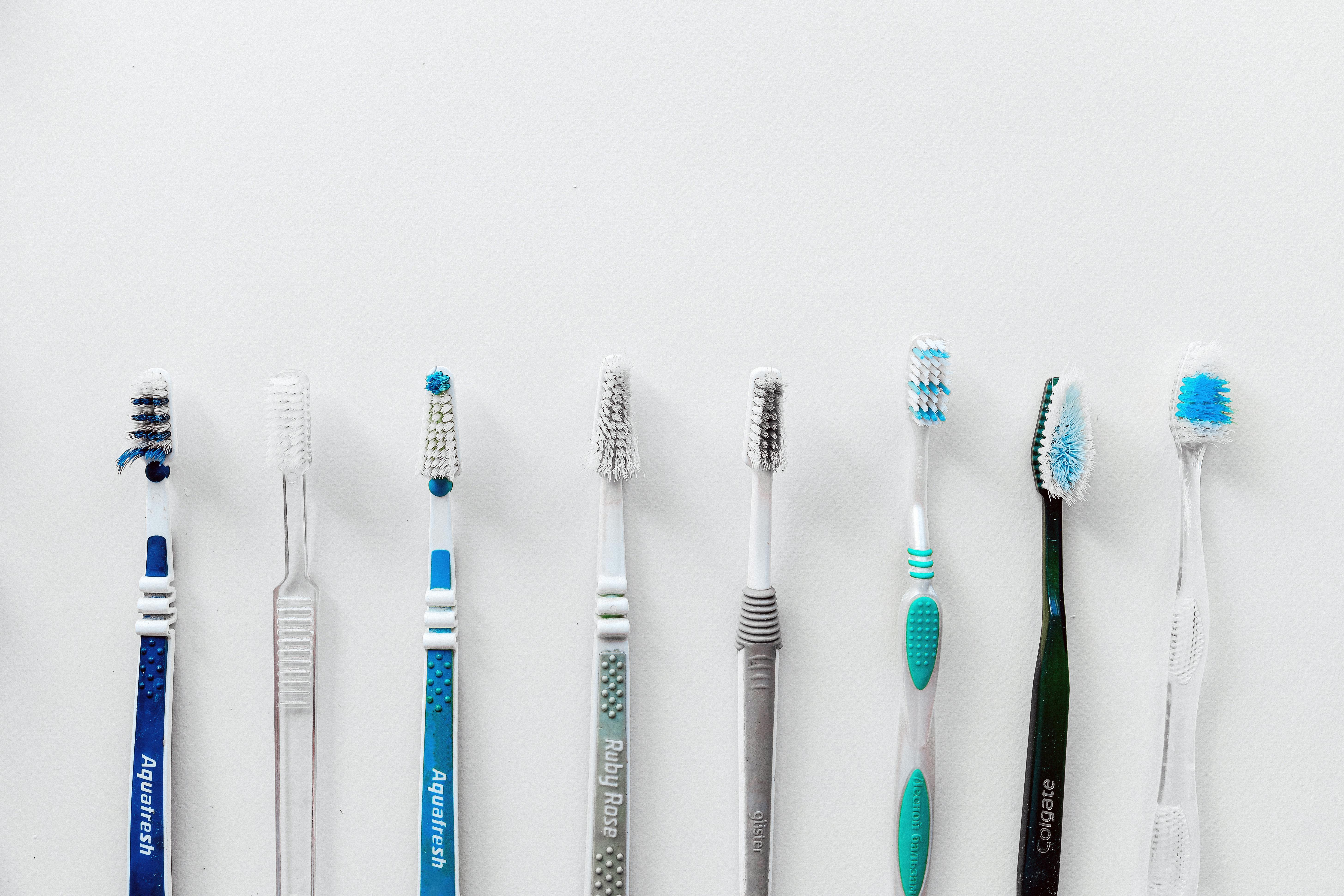 Diverse selection of toothbrushes lined up for dental hygiene focus with copy space.